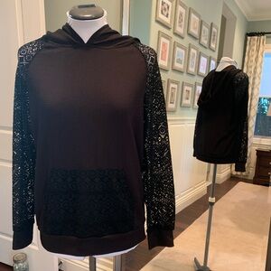 Small black hoodie with lace sleeves and pocket.